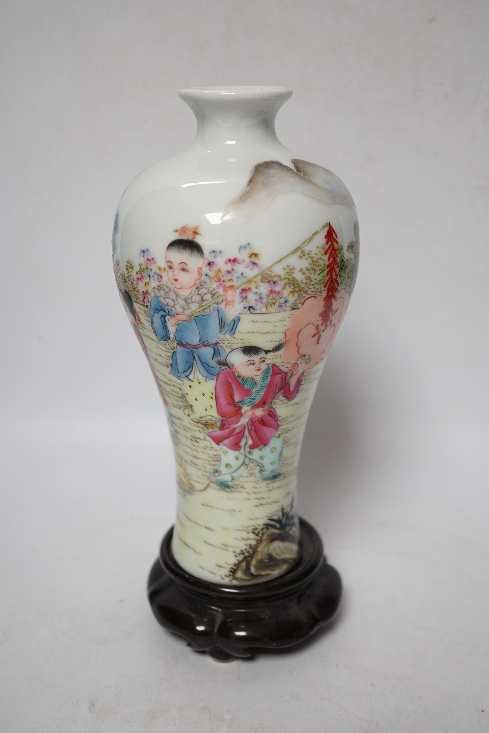 A Chinese famille rose vase, a rice dish, saucer and wooden stands